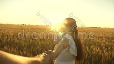 美丽的母亲带着女儿带着麦子走在田野上，牵着心爱的男人的手。 母亲、孩子和